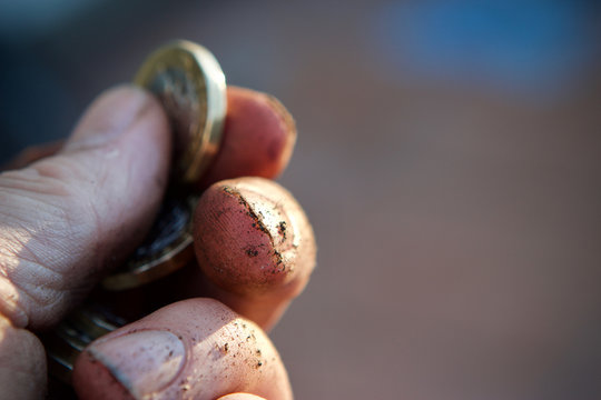 Pound coin held between finger and thumb