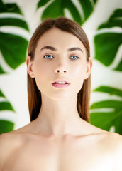 Portrait of young beautiful woman with perfect skin on tropical background.