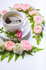 Vertical web banner Valentine's day flower arrangement. Rose, hawthorn flowers, rowan leaves and cup coffee on a white background. Floral pattern.