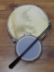 Fototapeta premium Close-up of two Brazilian percussion musical instruments: pandeiro (tambourine) and tamborim with drumstick on a wooden surface. These instruments are widely used to accompany samba music.
