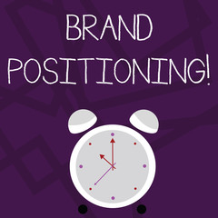 Writing note showing Brand Positioning. Business concept for creating a unique impression in the minds of the customers Colorful Round Analog Two Bell Alarm Desk Clock with Seconds Hand photo