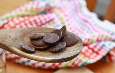 Chocolate wafers on a wooden spoon with colorful towel 