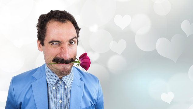 Funny man with mustache holding a flower in his mouth, Valentine's Day background