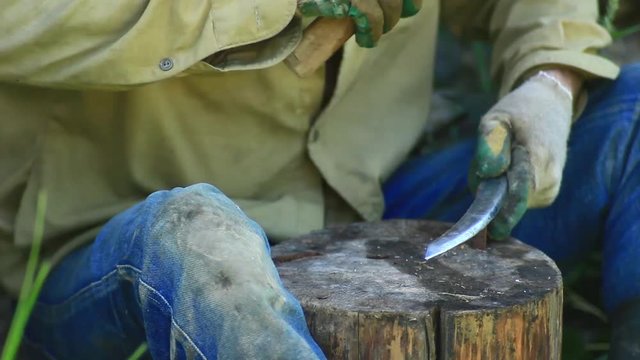 traditional iron forging, artisan sharpens a sharp knife blade with a hammer.