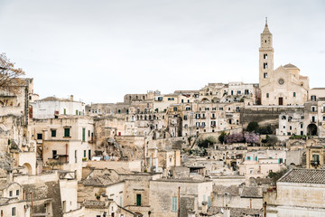 Obraz premium Long panoramic views of the rocky old town of Matera with its stone roofs.