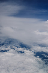 Plane window view with blue sky and beautiful clouds. As seen through window of an aircraft. View of wing & ocean. Airplane from city Bangkok to island Bali.