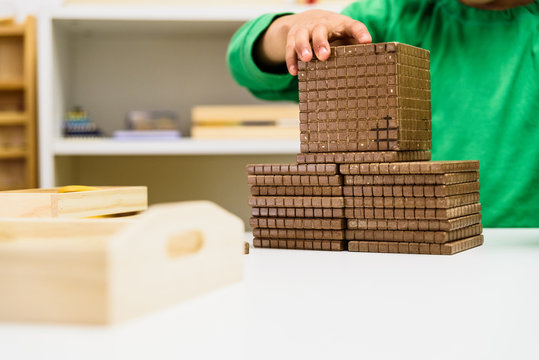 Child placing some blocks to count numbers is his house, concept of homeschooling.