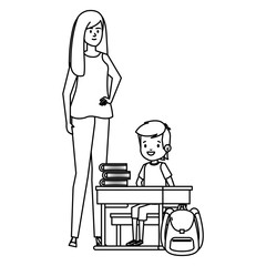 student boy seated in school desk with female teacher