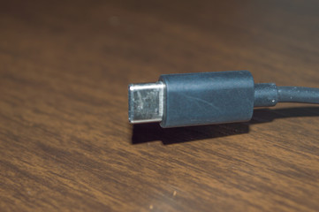black cable usb type c details, on wooden table