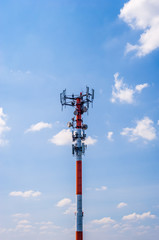 Thick red and white antenna on blue sky.