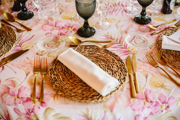 Outdoor tables for an elegantly decorated wedding reception, with lovely floral centerpieces and vintage style tableware and cutlery.