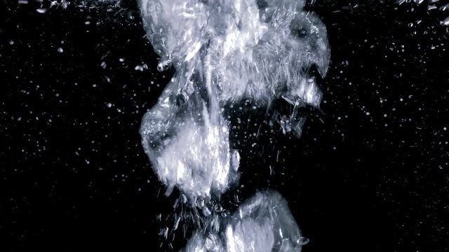 Vigorously bubbling water. Boiling effect. Air particles moving fast on black background.