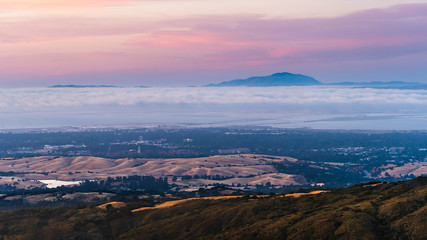 Clouds and fog at twilight over Silicon Valley and the San Francisco bay area; Stanford University visible under a layer of clouds; Mt Diablo in the background;