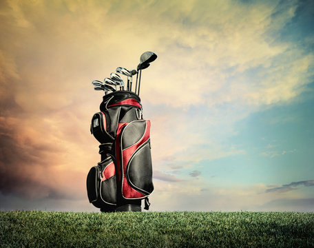 Golf clubs on grass against dramatic clouds