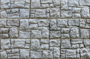 Wall made of artificial stone. Finishing the facade of the building. Texture.