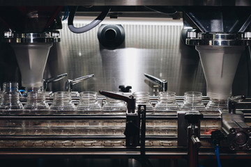 pharmaceutical industry, medicine pills are filling in the plastic bottle on production line machine conveyor at the medical factory. selective focus.