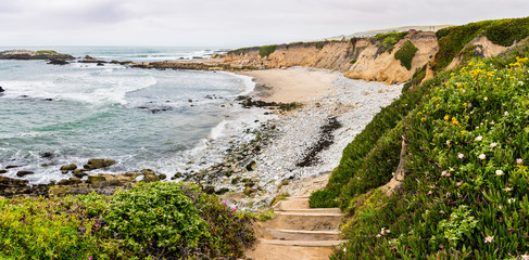 Stairs going down to a sandy beach on the Pacific Ocean coastline, Pescadero State Beach, California