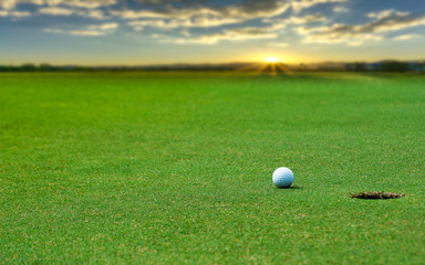 White Golf ball on green course to be shot on blurred beautiful landscape of golf course in bright day time with copy space. Sport, Recreation, Relax in holiday concept	