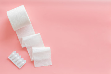 Disease of colon concept with toilet paper roll and rectal suppository on pink background top view mock up