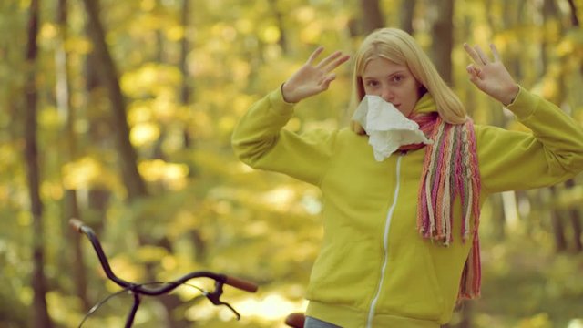 Young woman blowing nose at nature. Young woman with handkerchief. Woman makes a cure for the common cold.