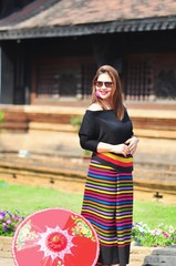 Middle aged Thai lady in colourful northern Thai style costume at outdoor tourist place background in Chiang Mai Lanna Thailand 