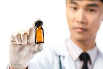 Asian scientist hand holding empty small brown medicine bottle .