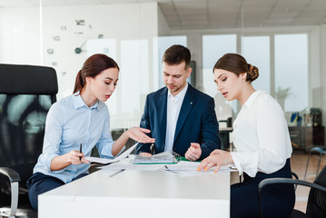 Office workers creating a business idea in modern environment and discussing strategy in a creative team of professionals