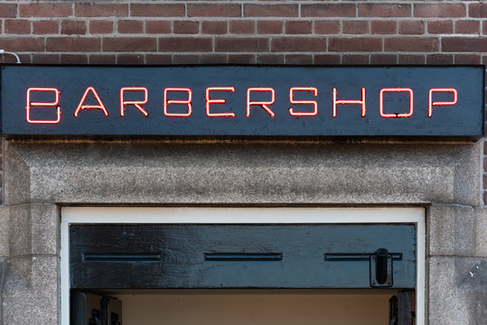 Red Barbershop Neon Sign On A Brick Wall In Day Light