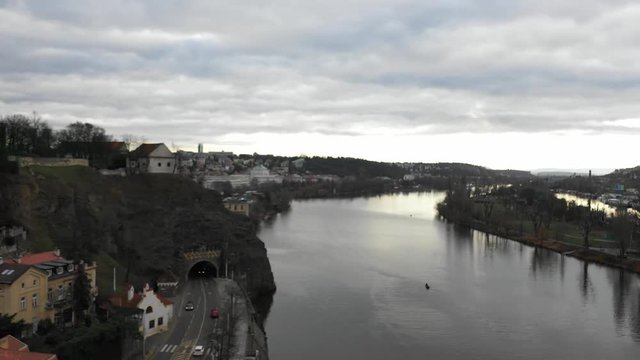 4K Aerial drone following Vlak Zeleznicni Train as it crosses a bridge over a river onto the other side of beautiful Prague