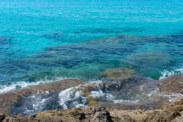 Transparent azure waters with rocky bottom near mountainous Crete island, Greece.