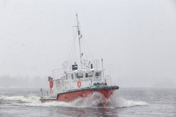 Test the motor boat on the Kama River in the late fall in snowfall