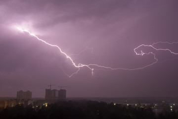 Lightning strike over city in night. Thunderstorm