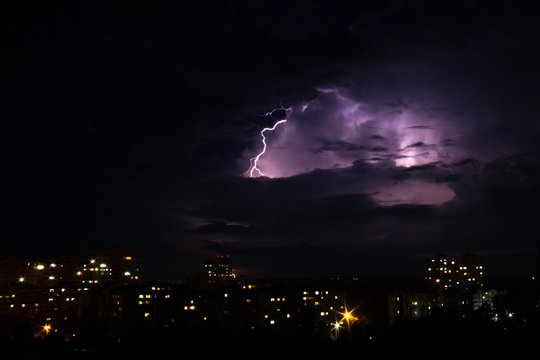 Lightning strike over city in night. Thunderstorm