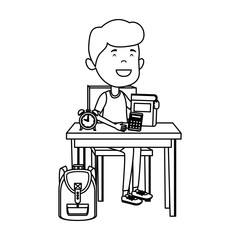 happy student boy with supplies seated in school desk