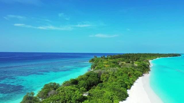 drone aerial footage of tropical island with long white sand beach shore and palms around surrounded by crystal clean ocean water thailand