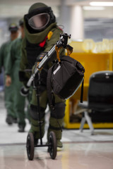 EOD officer in The explosive ordnance disposal suit take off the bomb bag with remote arm
