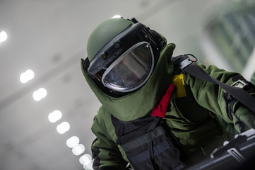 EOD officer in The explosive ordnance disposal suit searching bomb in the building room