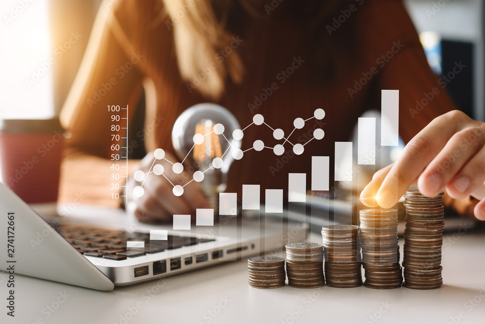 Poster business hand holding lightbulb with using laptop computer and money stack in office. idea saving en