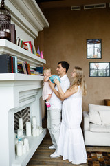 Tender family hugs. Happy pregnant mom, dad holds the baby in his arms at home