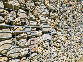 gabion fencing wall made of natural stone and metal grid. popular element of design for garden
