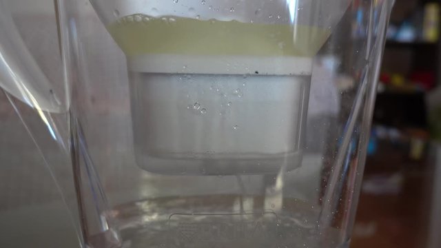 4K Pouring water in filter pitcher, close up, audio