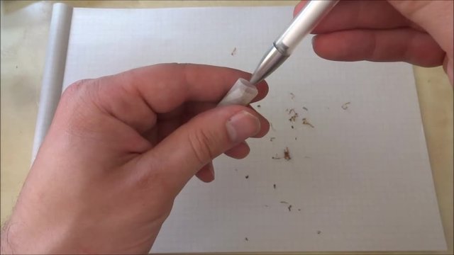 Stuffing a joint with a biro for better density and firmness. The finishing touches of making a cannabis joint.