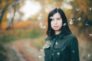 Dreamy beautiful girl in airy white fluff on bokeh background with yellow leaves. Inspired girl in...