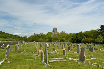 The historic landmark outline of Corfe Castle above the fields in Dorset