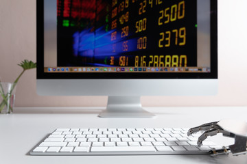 Robot hand, ordering on a laptop keyboard, an exchange trade. Robot trading system is a computer trading program that automatically submits trades to an exchange without any human interventions.