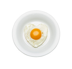 White plate with scrambled eggs in the shape of a heart, isolated on white.