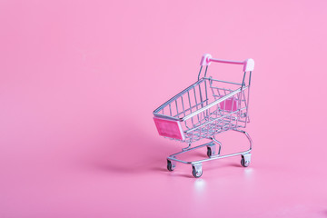 Shopping cart over pink background