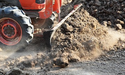 tractor push clot soil after pour from truck