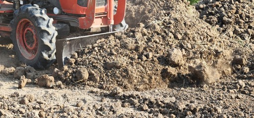 tractor push clot soil after pour from truck