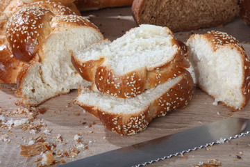 Composition with sliced wicker bread with a knife closeup